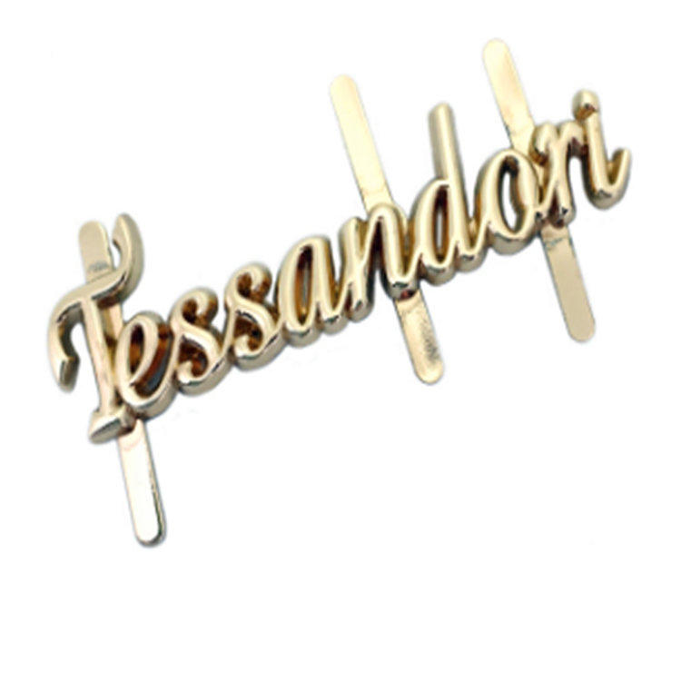 Goldener personalisierter Buchstabenlogo-Zapfen auf der hinteren Metallplatte für die Tasche